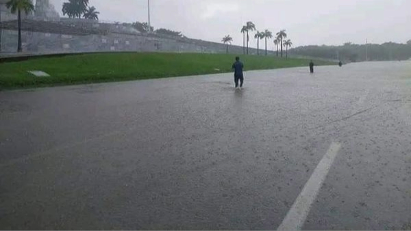 Cubanos caminando por una calle inundada en La Habana.