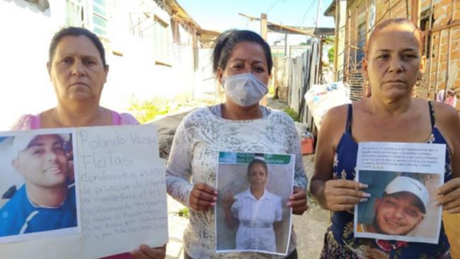 Madres de presos políticos del 11J con fotos de sus hijos.