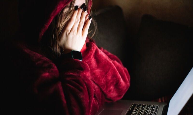 Una joven agobiada ante la pantalla de una computadora.