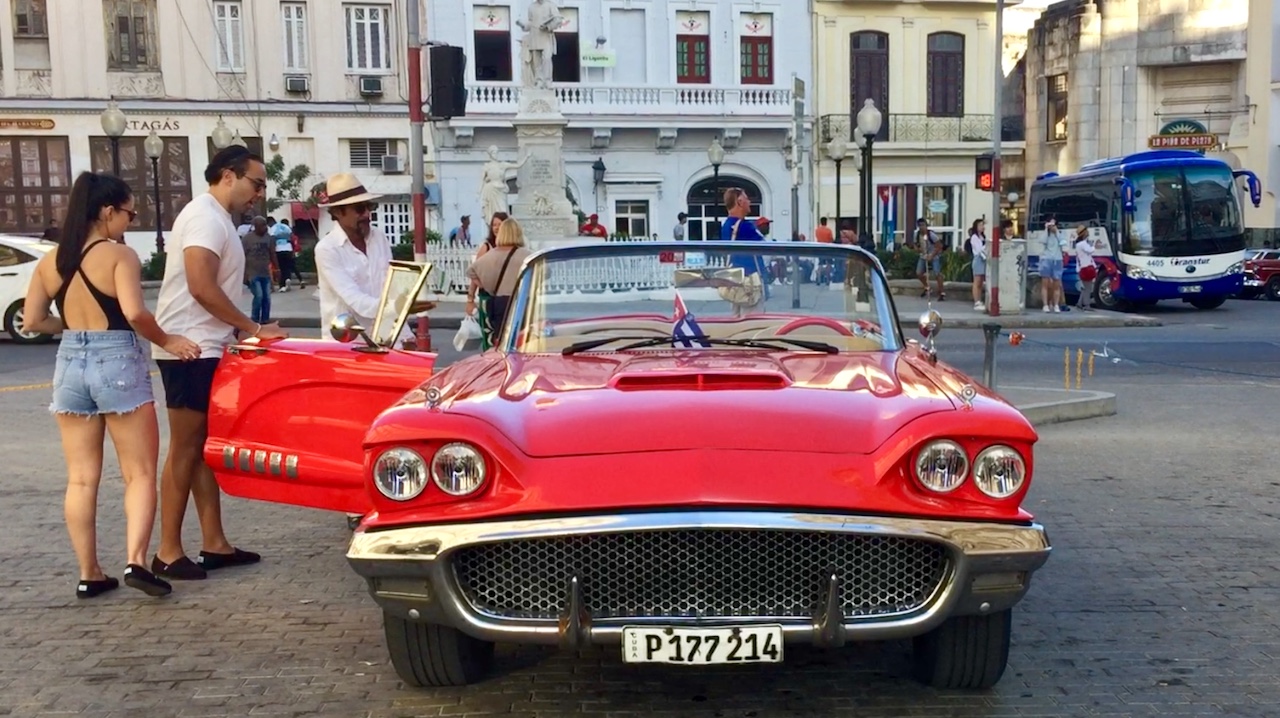 Turistas subiendo a un almendrón en La Habana.