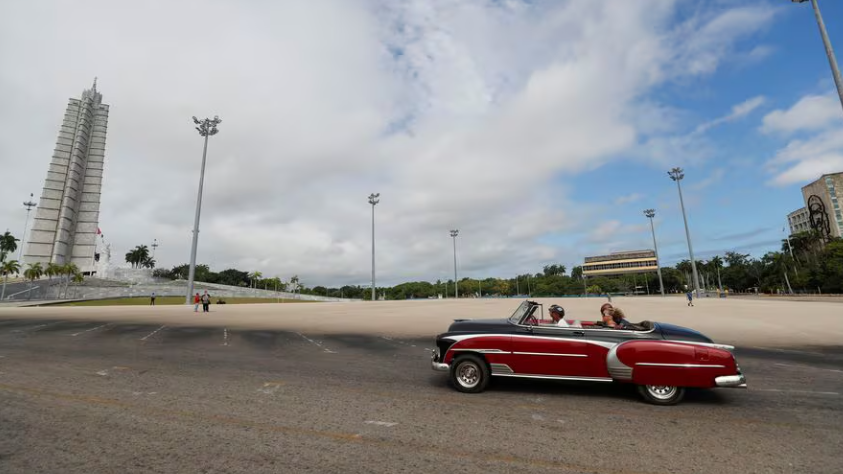 Turistas en un carro de época en la Plaza de la Revolución de La Habana.